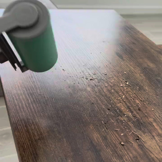 The large hand roller in action cleaning sand off a wooden table