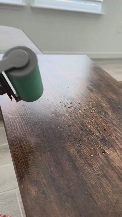 The large hand roller in action cleaning sand off a wooden table