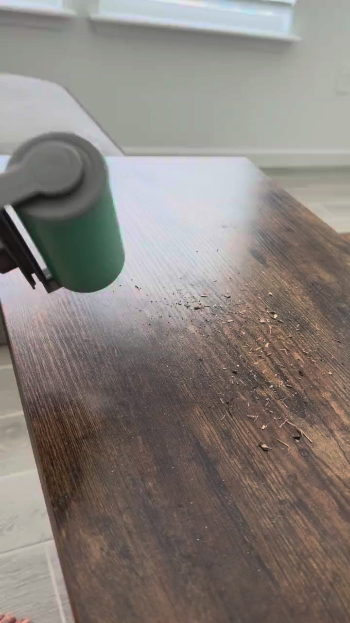 The large hand roller in action cleaning sand off a wooden table