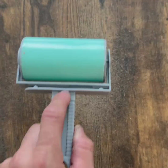 The large hand roller in action cleaning sand off a wooden table