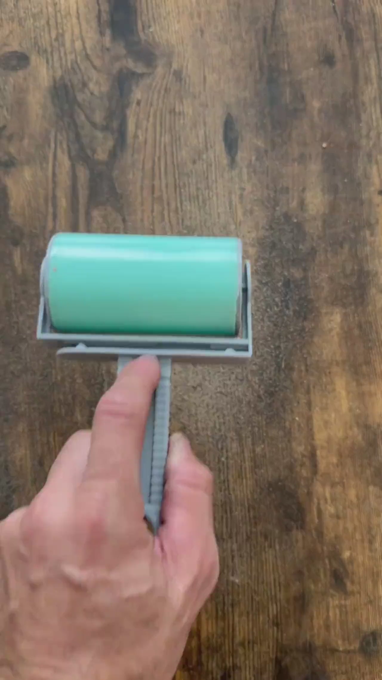 The large hand roller in action cleaning sand off a wooden table